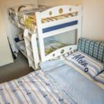 Zimmer mit Doppelbett, Schlafcouch und Kinderstockbett mit Matratzen.