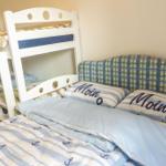 Zimmer mit Doppelbett und Kinderstockbett mit Seemannsmotiven.