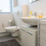 Badezimmer mit Toilette, Waschbecken und Heizkörper