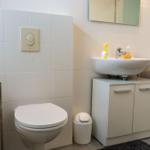 Badezimmer mit Toilette, Waschbecken und Spiegel