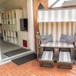 Terrasse mit Strandkorb und Blick ins Wohnzimmer.