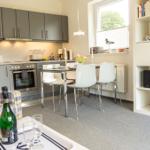 Küche, Essbereich und Wohnbereich mit Sofa, Tisch und Bücherregal.