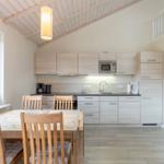 Küche mit Essbereich, Holztisch, Stühle und Mikrowelle.