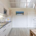 Küche mit Hochbett, Treppe und Küchenzeile.