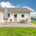 Haus mit Terrasse, Grill und Garten. Nebenhaus und Auto sind sichtbar.