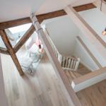 Haus mit Holzstufen und Balken, Sitzgelegenheit und Hängelampen