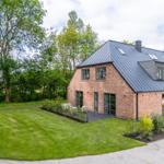 Moderne Backsteinhaus mit großem Garten und Terrasse.