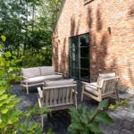 Terrasse mit Sitzgruppe vor Backsteinhaus mit Gartentüren