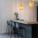 Kücheninsel mit Barhocker und hängenden Lampen.