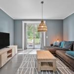 Wohnzimmer mit Sofa, Fernseher und Terrassentür.