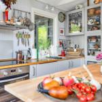 Küche mit Holzoberflächen, Edelstahlgeräten und Glasvitrinen mit Geschirr.