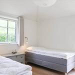 Zimmer mit zwei Betten, Fenster und Tür zum Garten.