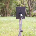 Ladestation im Garten mit Stromkabel und Stecker
