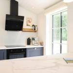 Küche mit Arbeitsplatte, Kochfeld und Fenster zur Aussicht.