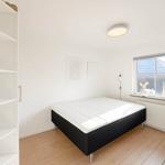 Schlafzimmer mit Bett, Fenster und Kleiderschrank.