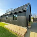 Moderne Holzhütte mit Terrasse und Dachterrasse.