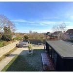 Terrasse mit Garten, Sitzgelegenheiten und Blick auf die Umgebung.