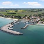 Hafen mit Booten, Strand und umliegenden Feldern.