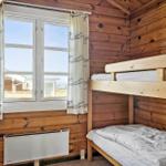 Kabine mit Doppelstockbett, Holzwand und Fenster mit Blick nach draußen.