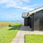 Haus mit Blick auf das Meer und grünen Gartenweg.