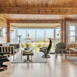 Wohnzimmer mit Holzwand, großem Fenster und Meerblick.