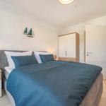 Schlafzimmer mit Bett, Nachttisch, Kleiderschrank und Stuhl.