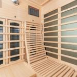 Innere eines Holzsaunas mit Sitzbänken und Heizung.