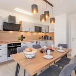 Küche mit Esstisch, moderner Ausstattung und Holzoptik