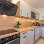 Moderne Küche mit Holz Arbeitsplatte und weißen Schränken