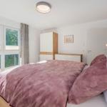 Schlafzimmer mit Bett, Fenster und Schrank.