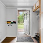 Eingangsbereich mit Waschmaschine, Schuhschrank und Blick auf den Garten.