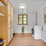 Wohnraum mit Kleiderschrank, Waschmaschine und Fenster.