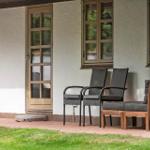 Terrasse mit Stühlen, Tür und Fenster an weißer Wand