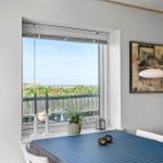 Esszimmer mit Blick auf den Strand und Meer. Tisch mit blauer Tischdecke und Wandbildern.