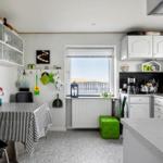 Küche mit Esstisch, Fenster und weißen Schränken.