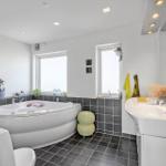 Bad mit Whirlpool, Waschbecken und Fenstern.