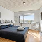 Schlafzimmer mit Bett, Fenster und weißen Wänden.