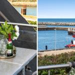 Terrasse mit Blumen und Sekt, Blick auf Hafen mit Rettungsboot.