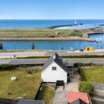 Wohnhaus mit Garten und Blick auf Hafen und Meer.