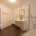 Badezimmer mit Dusche, Waschbecken und Toilette