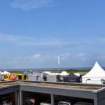 Rooftop-Parkplatz mit Blick auf Strand und Marktzelte.