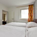 Schlafzimmer mit Bett, Fenster und Wandbild