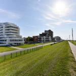 Grüner Strandweg mit Hotels und Blick aufs Meer.