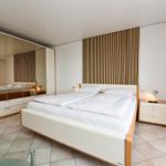Schlafzimmer mit Doppelbett, Spiegelschrank und Nachttisch.