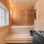 Sauna mit Holzverkleidung, Sitzbänken und Fenster