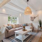 Wohnzimmer mit Sofa, Tisch und Wandbild. Holzdecke und Boden.