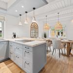 Küche mit Essbereich, Holzboden und weißen Wänden.