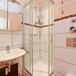 Badezimmer mit Dusche, Waschbecken und Spiegel