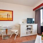 Wohnzimmer mit Esstisch, TV-Schrank und Balkontür.