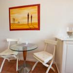 Kleiner Essbereich mit Tisch, zwei Stühlen und Wandbild.